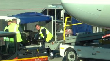 Krakow, Polonya - 20 Ekim 2024 Krakow Havaalanı. Kalkıştan önce uçak kontrolleri (biniş). Havaalanı çalışanı uçağa servis yapıyor. Bagaj yükleme (boşaltma). Yolcular (varış). Ryanair