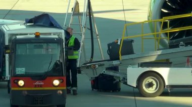 Krakow, Polonya - 20 Ekim 2024 Krakow Havaalanı. Kalkıştan önce uçak kontrolleri (biniş). Havaalanı çalışanı uçağa servis yapıyor. Bagaj yükleme (boşaltma). Yolcular (varış). Ryanair