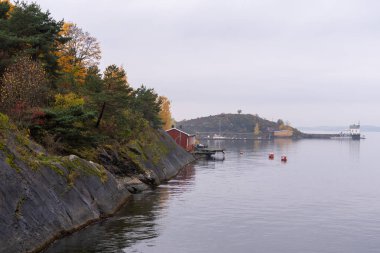 Oslo, Norveç - 20 Ekim 2024: Oslofjord (Oslofjorden), körfez ve ada manzarası. Sonbahar ormanı.