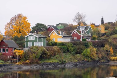 Oslo, Norveç - 20 Ekim 2024: Oslofjord (Oslofjorden), yazlık ev ve yazlık ev manzarası. Evleri eğlence için çerçevelet. Ormanın ve kayaların arasında bir kulübe. Çok renkli özel evler.