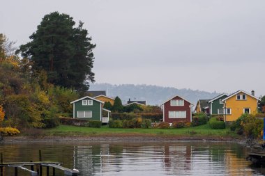 Oslo, Norveç - 20 Ekim 2024: Oslofjord (Oslofjorden), yazlık ev ve yazlık ev manzarası. Evleri eğlence için çerçevelet. Ormanın ve kayaların arasında bir kulübe. Çok renkli özel evler.