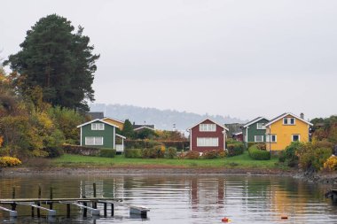 Oslo, Norveç - 20 Ekim 2024: Oslofjord (Oslofjorden), yazlık ev ve yazlık ev manzarası. Evleri eğlence için çerçevelet. Ormanın ve kayaların arasında bir kulübe. Çok renkli özel evler.