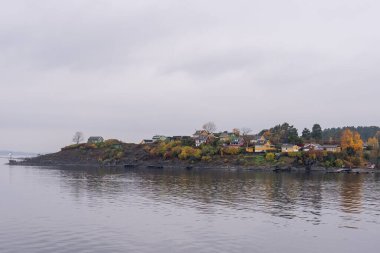 Oslo, Norveç - 20 Ekim 2024: Oslofjord (Oslofjorden), yazlık ev ve yazlık ev manzarası. Evleri eğlence için çerçevelet. Ormanın ve kayaların arasında bir kulübe. Çok renkli özel evler.