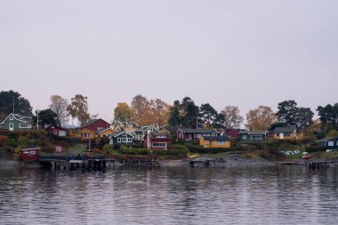 Oslo, Norveç - 20 Ekim 2024: Oslofjord (Oslofjorden), yazlık ev ve yazlık ev manzarası. Evleri eğlence için çerçevelet. Ormanın ve kayaların arasında bir kulübe. Çok renkli özel evler.