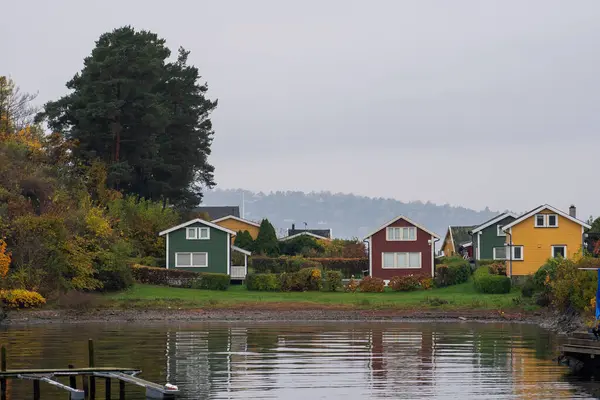 Oslo, Norveç - 20 Ekim 2024: Oslofjord (Oslofjorden), yazlık ev ve yazlık ev manzarası. Evleri eğlence için çerçevelet. Ormanın ve kayaların arasında bir kulübe. Çok renkli özel evler.