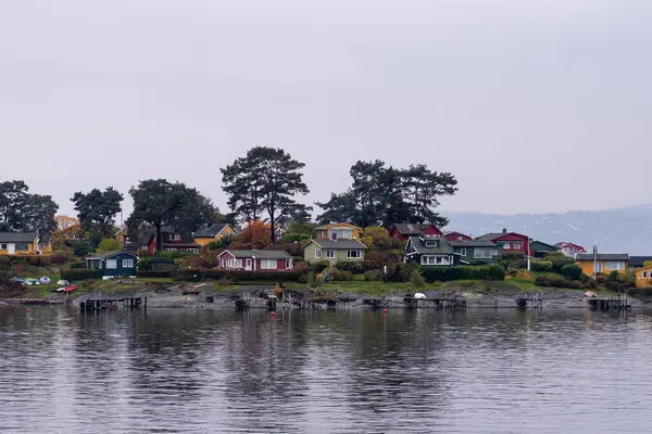 Oslo, Norveç - 20 Ekim 2024: Oslofjord (Oslofjorden), yazlık ev ve yazlık ev manzarası. Evleri eğlence için çerçevelet. Ormanın ve kayaların arasında bir kulübe. Çok renkli özel evler.