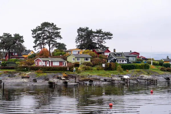 Oslo, Norveç - 20 Ekim 2024: Oslofjord (Oslofjorden), yazlık ev ve yazlık ev manzarası. Evleri eğlence için çerçevelet. Ormanın ve kayaların arasında bir kulübe. Çok renkli özel evler.