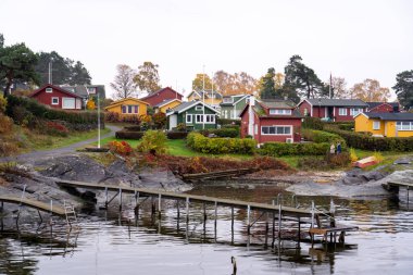 Oslo, Norveç - 20 Ekim 2024: Oslofjord (Oslofjorden), yazlık ev ve yazlık ev manzarası. Evleri eğlence için çerçevelet. Ormanın ve kayaların arasında bir kulübe. Çok renkli özel evler.