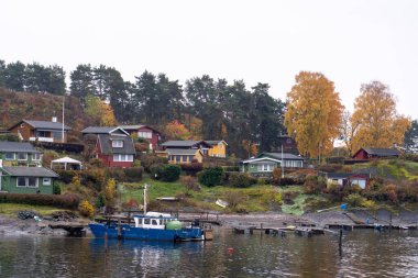 Oslo, Norveç - 20 Ekim 2024: Oslofjord (Oslofjorden), yazlık ev ve yazlık ev manzarası. Evleri eğlence için çerçevelet. Ormanın ve kayaların arasında bir kulübe. Çok renkli özel evler.