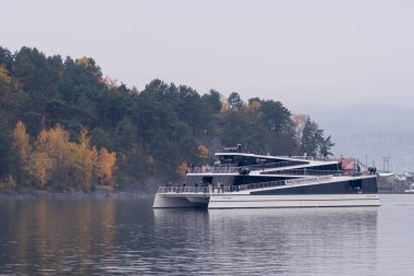 Oslo, Norveç - 19 Ekim 2024 Ada Feribotları Oslofjord 'da. Yeşil tepeler ve kayalık adalar tarafından çerçevelenmiş Oslofjord 'un berrak sularında bir feribot süzülüyor.. 