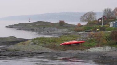 Oslo, Norveç - 19 Ekim 2024: Oslofjord (Oslofjorden), yazlık ev ve yazlık ev manzarası. Evleri eğlence için çerçevelet. Ormanın ve kayaların arasında bir kulübe. Çok renkli özel evler.