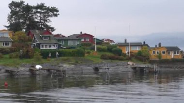 Oslo, Norveç - 19 Ekim 2024: Oslofjord (Oslofjorden), yazlık ev ve yazlık ev manzarası. Evleri eğlence için çerçevelet. Ormanın ve kayaların arasında bir kulübe. Çok renkli özel evler.