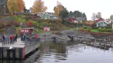 Oslo, Norveç - 19 Ekim 2024: Oslofjord (Oslofjorden), yazlık ev ve yazlık ev manzarası. Evleri eğlence için çerçevelet. Ormanın ve kayaların arasında bir kulübe. Çok renkli özel evler.