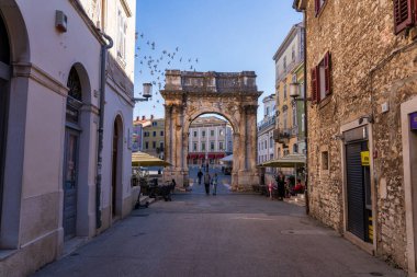 Pula, Hırvatistan - 3 Kasım 2024: Antik Roma zafer kemeri Sergii 'nin kemeri. Kemer Sergius, Lucius, Sergius, Lepidus gibi Sergian ailesinin üç üyesine adanmıştır..