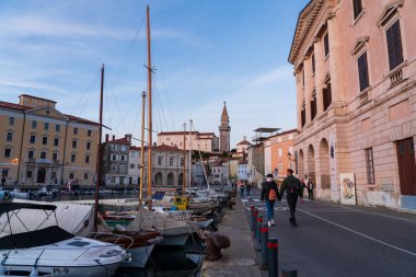 Piran, Slovenya - 3 Kasım 2024: Yat limanı manzarası. Gün batımında yatları olan şehir seti..