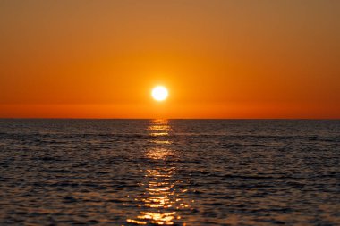 Marina di Pisa, Pisa ili, İtalya - 4 Kasım 2024: Şahane gün batımı. Güneş denize karşı batıyor. Güneşin deniz suyundaki yansıması..