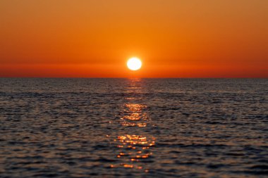 Marina di Pisa, Pisa ili, İtalya - 4 Kasım 2024: Şahane gün batımı. Güneş denize karşı batıyor. Güneşin deniz suyundaki yansıması..