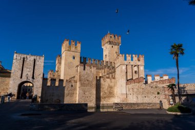 Sirmione, İtalya - 6 Kasım 2024: Sirmione 'nin tarihi merkezi Scaliger Castle, Garda Gölü kıyısında. Castello Scaligero di Sirmione