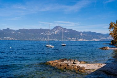 Garda Gölü, İtalya - 6 Kasım 2024: Dağlı ve yatlı manzara.