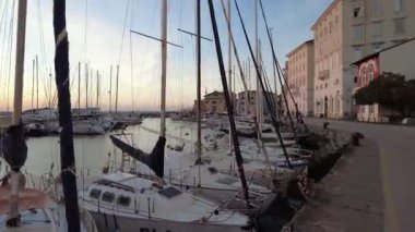 Piran, Slovenya - 3 Kasım 2024: İkamet evleri olan şehir sokağı. Gün batımında evleri olan deniz kıyısında..