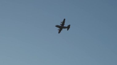 Marina di Pisa, Pisa ili, İtalya - 4 Kasım 2024: Bir kargo uçağı akşam güneşinin altında denizin üzerinde uçuyor. Askeri uçak C-130 Süper Hercule