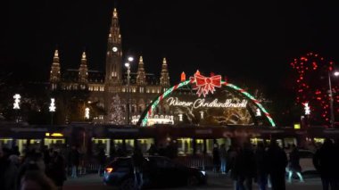 Viyana, Avusturya - 13 Aralık 2024: Rathaus Park ve Viyana Belediye Binası akşam manzarası. Noel pazarı. Yeni yıl aydınlanması. Meydandaki insanlar.