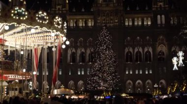 Viyana, Avusturya - 13 Aralık 2024: Rathaus Park ve Viyana Belediye Binası akşam manzarası. Noel pazarı. Yeni yıl aydınlanması. Meydandaki insanlar.