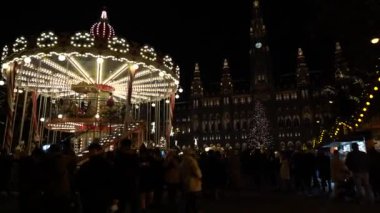 Viyana, Avusturya - 13 Aralık 2024: Rathaus Park ve Viyana Belediye Binası akşam manzarası. Noel pazarı. Yeni yıl aydınlanması. Meydandaki insanlar.