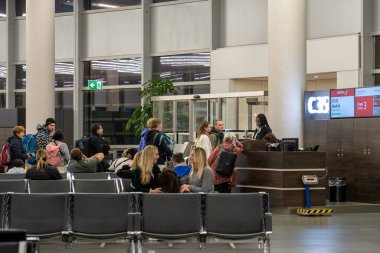 Viyana, Avusturya - 18 Ocak 2025: Viyana Havaalanı 'nın kapısındaki yolcular. Turistler uçağa binmek için sırada bekliyorlar. Giriş kapısı, biniş belgelerini kontrol edin..