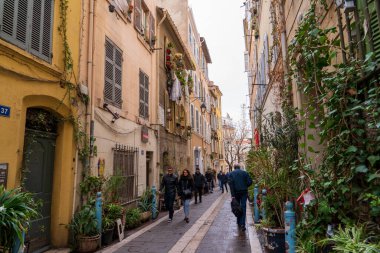 Marsilya, Fransa, 2 Şubat 2025: İnsanların geçtiği bir cadde manzarası ve eski evler. Graffiti. 