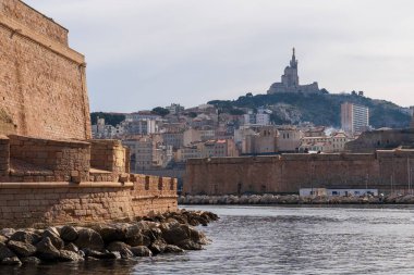 Marsilya, Fransa - 2 Şubat 2025: Saint-Victor Manastırı ve Notre-Dame de la Garde. Aziz Cassian 'ın 5. yüzyıldan kalma lahit yakınlarında kurduğu güçlendirilmiş manastır şimdi onun lahitine ev sahipliği yapıyor. Notre-Dame de la Garde, Büyük Bazilika: