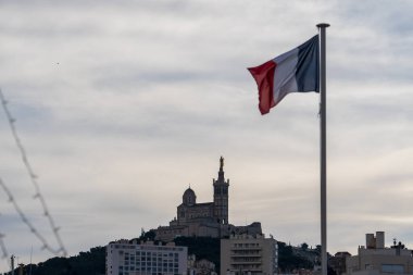 Marseille, France - February 2, 2025: View of Notre-Dame de la Garde, and the flag of France. National flag of France clipart