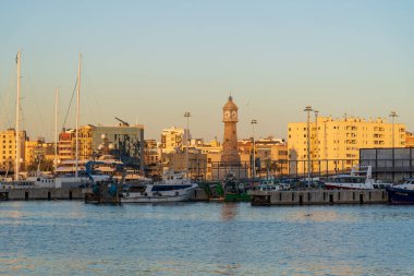 Barselona, İspanya - 3 Şubat 2025: Şehir merkezi manzarası. Demirlemiş yatlar. Saati olan deniz fenerinin manzarası, Torre del Rellotge Barceloneta.