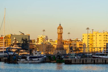 Barselona, İspanya - 3 Şubat 2025: Şehir merkezi manzarası. Demirlemiş yatlar. Saati olan deniz fenerinin manzarası, Torre del Rellotge Barceloneta.