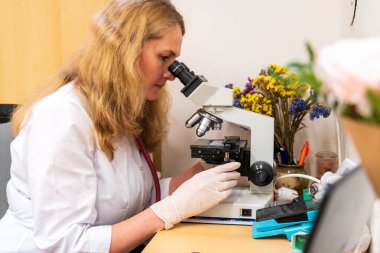 Brno, Çek Cumhuriyeti - 28 Mart 2025: Laboratuvar testleri. Bir veteriner mikroskoba bakar..