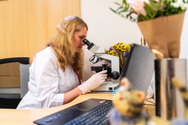 Brno, Çek Cumhuriyeti - 28 Mart 2025: Laboratuvar testleri. Bir veteriner mikroskoba bakar..