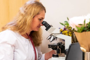 Brno, Çek Cumhuriyeti - 28 Mart 2025: Laboratuvar testleri. Bir veteriner mikroskoba bakar..