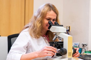 Brno, Çek Cumhuriyeti - 28 Mart 2025: Laboratuvar testleri. Bir veteriner mikroskoba bakar..