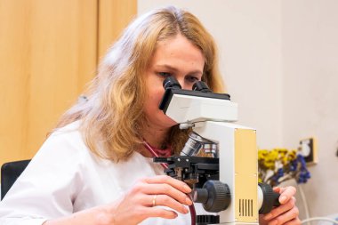 Brno, Çek Cumhuriyeti - 28 Mart 2025: Laboratuvar testleri. Bir veteriner mikroskoba bakar..