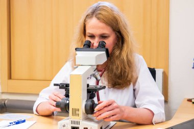 Brno, Çek Cumhuriyeti - 28 Mart 2025: Laboratuvar testleri. Bir veteriner mikroskoba bakar..