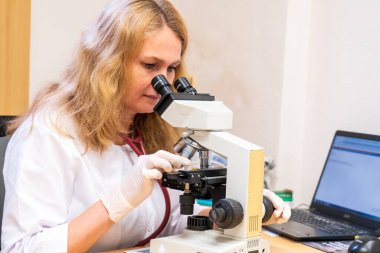 Brno, Çek Cumhuriyeti - 28 Mart 2025: Laboratuvar testleri. Bir veteriner mikroskoba bakar..