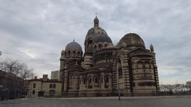 Marsilya, Fransa, 2 Şubat 2025: Çağdaş binaların çerçevelediği modern bir şehir caddesinden alınan La Major Katedrali (Marsilya Katedrali) manzarası. Katedralin görkemli mimarisi.