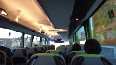 İspanya, Barselona, Avrupa - 3 Şubat 2025: Flixbus otobüsündeki yolcular. Bir Flixbus yolcu otobüsünün içi. Yolculuk sırasında bir cihaz kullanan yolcular. Pencereden dışarı bakıyorum.