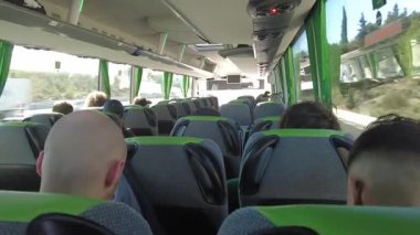 İspanya, Barselona, Avrupa - 3 Şubat 2025: Flixbus otobüsündeki yolcular. Bir Flixbus yolcu otobüsünün içi. Yolculuk sırasında bir cihaz kullanan yolcular. Pencereden dışarı bakıyorum.