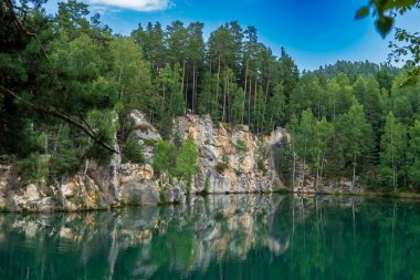 Adrspach, Çek Cumhuriyeti - 20.07.2025: Piskovna Gölü 'ndeki Adrspach-Teplice Kayaları manzarası. Orman ve kayalar.