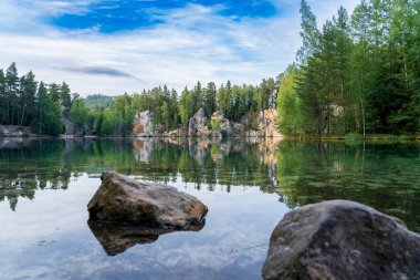 Adrspach, Çek Cumhuriyeti - 20.07.2025: Piskovna Gölü 'ndeki Adrspach-Teplice Kayaları manzarası. Ağaçların ve kayaların arasında bir orman gölü.