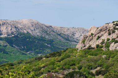 KRK Island, Baska, Croatia - April 18, 2025: View of the mountains and the village of Baska.