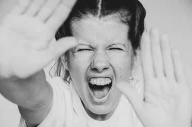 Kız çığlık atıyor ve elleriyle yüzünü kapatıyor. Arka planı izole ediyor. Kötülük ve çığlıklar.