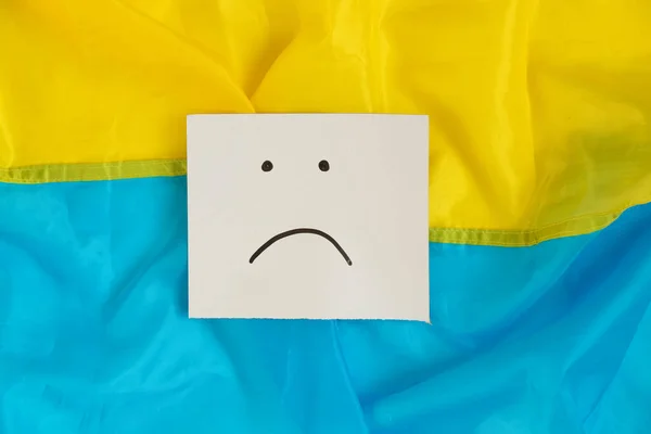 Smutný Emotikon Nakreslený Papíře Leží Vlajkách Ukrajiny Špatná Nálada — Stock fotografie