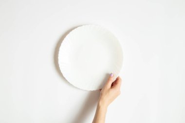 Beyaz, temiz bir plaka beyaz arka planda bir kızın ellerinde.